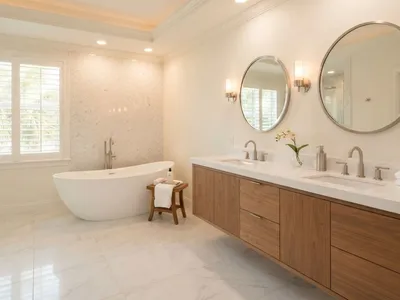 Completed luxury bathroom remodel with freestanding soaking tub, marble tile, and dual vanity